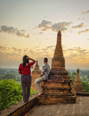Foto de Una pareja visita Bagan Myanmar, Sunrise por encima de los templos y pagodas de Bagan Myanmar, Sunrise Pagan Myanmar templo y pagoda. Hombres y mujeres en una vieja pagoda durante las vacaciones en Myanmar - Imagen libre de derechos