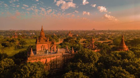 Photo for Couple of men and woman watching the sunrise in Bagan on top of an old pagoda, men woman sunset Bagan .old city of Bagan Myanmar, Pagan Burma Asia old ruins Pagodas and Temples - Royalty Free Image