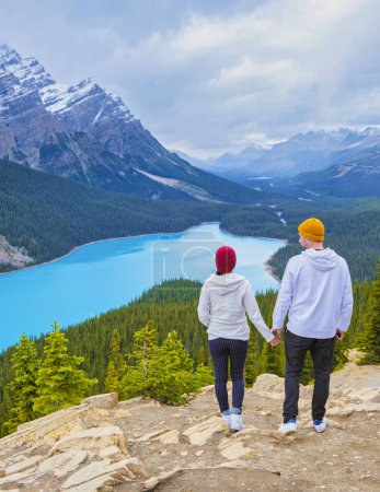 Foto de Lake Peyto in Banff National Park, Canada. Mountain Lake as a fox head is popular among tourists in Canada driving the icefields parkway. A couple of men and women looking out over the lake. - Imagen libre de derechos