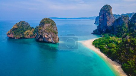 Téléchargez les photos : Railay Beach Krabi Thaïlande, la plage tropicale de Railay Krabi un jour d'été, une plage blanche avec une turque couleur océan avec des falaises de calcaire en Thaïlande pendant le lever du soleil - en image libre de droit