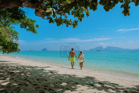 Téléchargez les photos : Un couple multiracial d'hommes et de femmes sur la plage de l'île de Koh Kradan en Thaïlande pendant les vacances de lune de miel en Thaïlande du Sud. - en image libre de droit