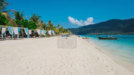 Beach chairs and sunbeds on the beach of Koh Lipe Island Southern Thailand with turqouse colored ocean and white sandy beach at Ko Lipe.