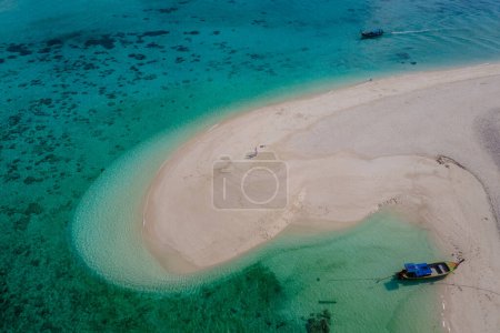 Photo for Couple of men and women at a white sandbank in the ocean of Koh Lipe Island Southern Thailand. - Royalty Free Image