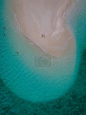 Photo for Couple of men and women at a white sandbank in the ocean of Koh Lipe Island Southern Thailand, with turqouse colored ocean - Royalty Free Image