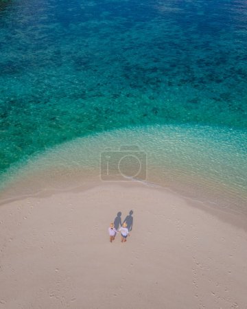 Foto de Pareja de hombres y mujeres en un banco de arena blanca en el océano de Koh Lipe Island Sur de Tailandia en un día soleado - Imagen libre de derechos