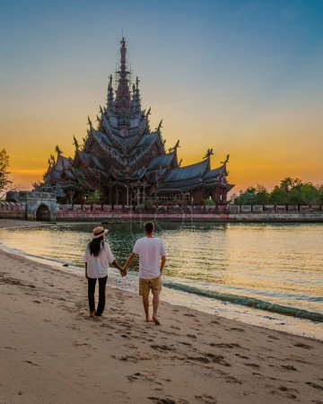 Téléchargez les photos : Sanctuaire de la Vérité, Pattaya, Thaïlande, temple en bois au bord de l'océan pendant le coucher du soleil sur la plage de Pattaya Chonburi Thaïlande, horizon de Pattaya au coucher du soleil, un couple en vacances à Pattaya - en image libre de droit