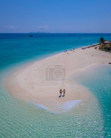 Téléchargez les photos : Couple d'hommes et de femmes sur un banc de sable blanc dans l'océan de Koh Lipe Island sud de la Thaïlande pendant les vacances détente sur la plage, vue sur drone d'en haut à un banc de sable - en image libre de droit