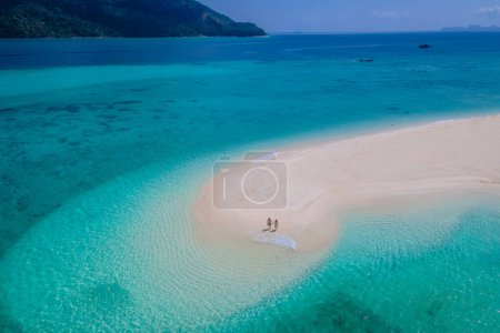 Foto de Pareja de hombres y mujeres en un banco de arena blanca en el océano de Koh Lipe Island sur de Tailandia durante las vacaciones relajándose en la playa, vista del dron desde arriba en un banco de arena - Imagen libre de derechos