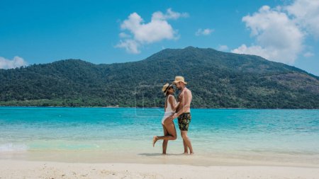 Téléchargez les photos : Couple d'hommes et de femmes sur la plage pendant les vacances à Koh Lipe Island sud de la Thaïlande, turqouse couleur océan et plage de sable blanc à Ko Lipe par une journée ensoleillée - en image libre de droit