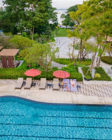 Foto de Vista del dron desde arriba en una pareja nadando en una piscina infinita en unas vacaciones de lujo en Tailandia, hombre y mujer en una piscina de un hotel de lujo en Tailandia de vacaciones - Imagen libre de derechos