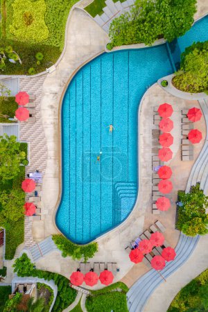 Téléchargez les photos : Vue sur drone d'en haut à un couple nageant dans une piscine à débordement sur des vacances de luxe en Thaïlande, homme et femme dans une piscine d'un hôtel de luxe en Thaïlande en vacances - en image libre de droit