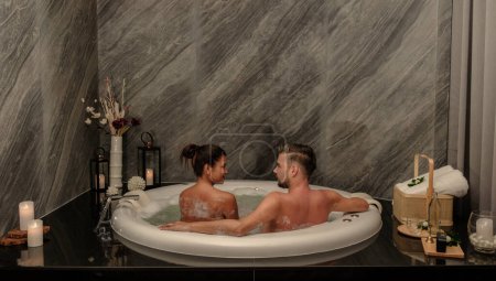 Téléchargez les photos : Un couple d'hommes et une femme dans une baignoire dans une salle de massage en Thaïlande dans un hôtel de luxe. hommes et femmes prenant un bain - en image libre de droit