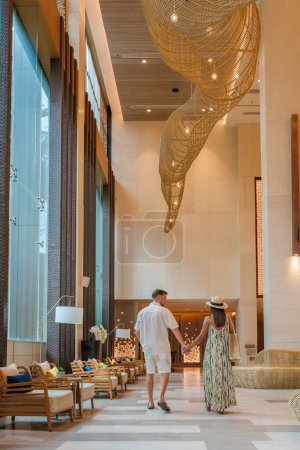 Foto de Un par de hombres y una mujer caminando en el vestíbulo de un hotel de lujo en Tailandia - Imagen libre de derechos