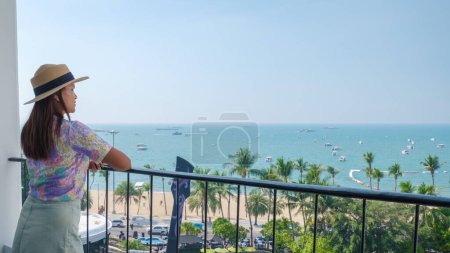 Photo for Pattaya Thailand 10 November 2023, woman on balcony looking at the ocean with swimming pool with the logo of the Hard Rock cafe and hotel on the beach road - Royalty Free Image
