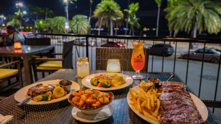 Photo for Pattaya Thailand 10 November 2023, Hard rock cafe and Hotel on the Beach Road, dinner table in the evening - Royalty Free Image