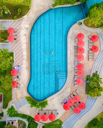 Foto de Vista del dron desde arriba en una pareja nadando en una piscina en unas vacaciones de lujo en Tailandia, hombre y mujer en una piscina de un hotel de lujo en Tailandia de vacaciones - Imagen libre de derechos