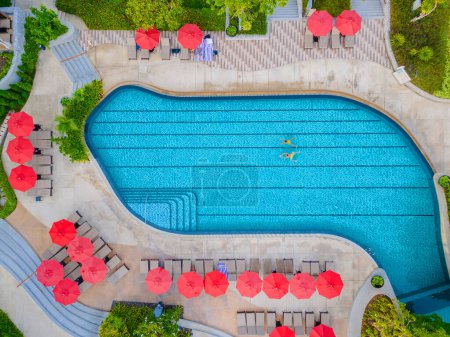 Foto de Vista del dron desde arriba en una pareja nadando en una piscina en unas vacaciones de lujo en Tailandia, hombre y mujer en una piscina de un hotel de lujo en Tailandia de vacaciones - Imagen libre de derechos