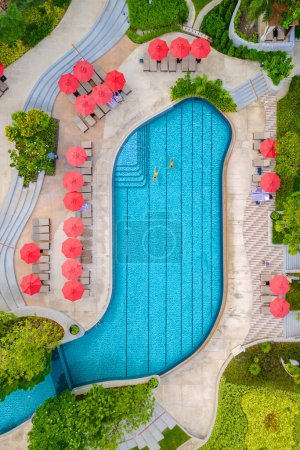 Foto de Vista del dron desde arriba en una pareja nadando en una piscina infinita en unas vacaciones de lujo en Tailandia, hombre y mujer en una piscina de un hotel de lujo en Tailandia de vacaciones - Imagen libre de derechos