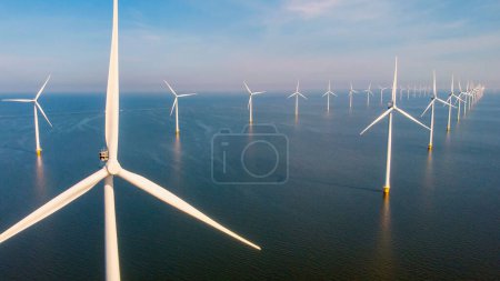 Foto de Turbinas de molinos de viento que generan energía verde eléctrica con un concepto de energía verde del cielo azul en los Países Bajos - Imagen libre de derechos