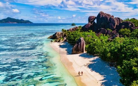 Téléchargez les photos : Anse Source d'Argent, La Digue Seychelles, un jeune couple d'hommes caucasiens et de femmes asiatiques sur une plage tropicale pendant des vacances de luxe, La Digue Seychelles - en image libre de droit