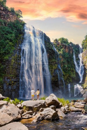 Foto de Mujeres asiáticas y hombres caucásicos de vacaciones en Sudáfrica visitan la ruta Panorama Sudáfrica, Lisbon Falls Sudáfrica, Lisbon Falls es la cascada más alta de Mpumalanga, Sudáfrica. - Imagen libre de derechos