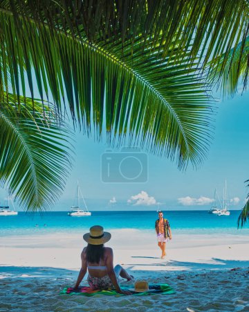 Foto de Anse Lazio Praslin Seychelles, una joven pareja de hombres y mujeres en una playa tropical durante unas vacaciones de lujo en Seychelles. - Imagen libre de derechos