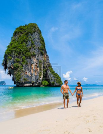 Foto de Railay Beach Krabi Tailandia, la playa tropical de Railay Krabi, un par de hombres en traje de baño y mujeres en bikini caminando por la playa, - Imagen libre de derechos