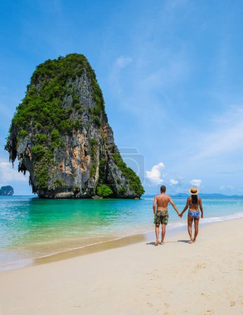 Téléchargez les photos : Railay Beach Krabi Thaïlande, la plage tropicale de Railay Krabi, quelques hommes en short de bain et des femmes en bikini marchant sur la plage, - en image libre de droit