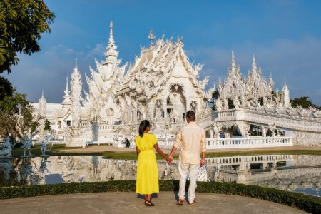 Téléchargez les photos : Un couple d'hommes et une femme visitent le temple blanc Chiang Rai Thaïlande, Wat Rong Khun, alias The White Temple, à Chiang Rai, Thaïlande. - en image libre de droit