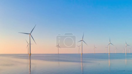 Foto de Turbinas de molinos de viento Parque al atardecer, turbinas de molinos de viento en el mar - Imagen libre de derechos