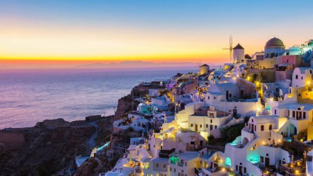 Foto de Puesta de sol en el océano de Oia Santorini Grecia, un pueblo griego tradicional en Santorini con iglesias encaladas y cúpulas azules en la hora azul de la noche - Imagen libre de derechos