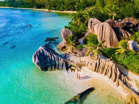 Téléchargez les photos : Anse Source d'Argent plage, Île La Digue, Seychelles, Drone vue aérienne de La Digue Seychelles vue aérienne de l'île tropicale, les hommes et les femmes à la plage pendant le coucher du soleil lors de vacances de luxe - en image libre de droit