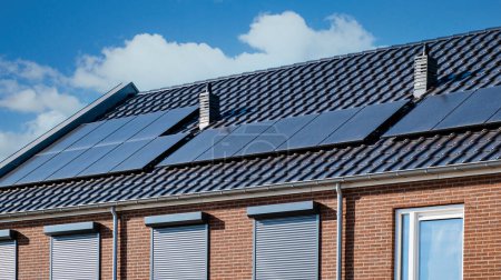 Foto de Casas de nueva construcción con paneles solares unidos en el techo, paneles solares que producen energía limpia en un techo de una casa residencial - Imagen libre de derechos