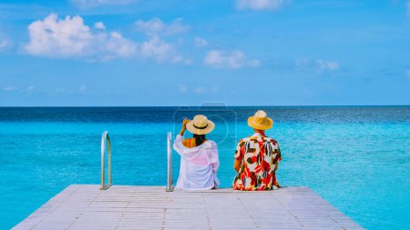 Foto de A couple visiting Playa Porto Marie beach Curazao, a white tropical beach with turqouse water ocean, A couple men and women on vacation in Curacao - Imagen libre de derechos