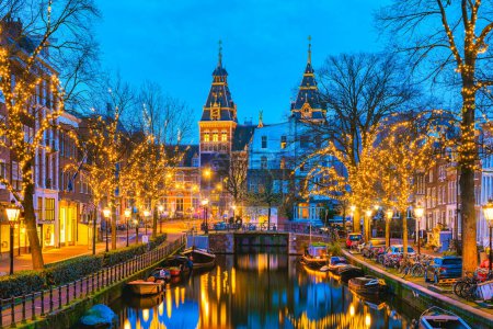 Foto de Amsterdam Países Bajos canales con luces de Navidad durante diciembre, canal centro histórico de Amsterdam por la noche en diciembre durante las vacaciones de Navidad en los Países Bajos - Imagen libre de derechos