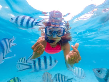 Foto de Mujer asiática en un viaje de snorkel en Samaesan Tailandia. bucear bajo el agua con peces Nemo en la piscina de coral de arrecife de mar. actividad de natación en unas vacaciones de playa de verano - Imagen libre de derechos