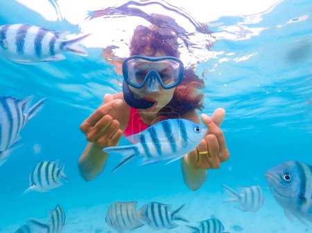 Téléchargez les photos : Femme asiatique en voyage de plongée en apnée à Samaesan Thaïlande. plongée sous-marine avec des poissons Nemo dans la piscine de récif corallien. activité de baignade pendant les vacances d'été à la plage - en image libre de droit