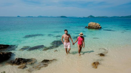 Foto de Un par de hombres europeos y una mujer asiática en un viaje en barco en Ko Kham Island Sattahip Chonburi Samaesan Tailandia, una pareja caminando en el océano en una isla tropical con ocen de color turquesa - Imagen libre de derechos