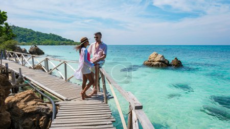 Téléchargez les photos : Un Européen et une Asiatique en bateau à Ko Kham Island Sattahip Chonburi Samaesan Thailand, un couple sur une jetée de pont en bois sur une île tropicale avec ocen turque - en image libre de droit