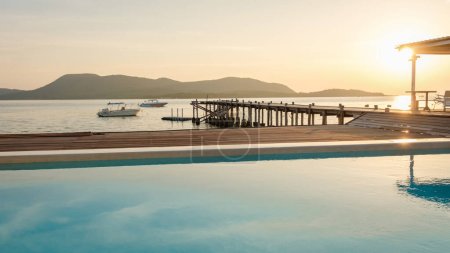 Photo for Swimming pool and wooden pier in the ocean during sunset in Samaesan Thailand. - Royalty Free Image