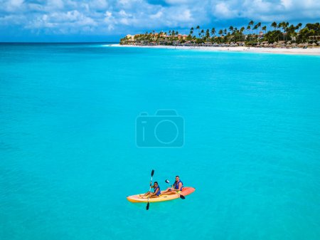 Photo for Couple Kayaking in the Ocean on Vacation in Aruba Island Caribbean Sea, A man and woman mid age kayak in the blue turqouse colored ocean water of Aruba - Royalty Free Image
