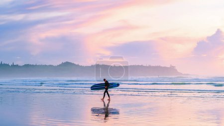 Téléchargez les photos : Tofino Beach Vancouver Island Pacific rim coast during sunset, surfeurs avec planche de surf au coucher du soleil sur la plage, Canada Vancouver Island Tofino Long beach - en image libre de droit