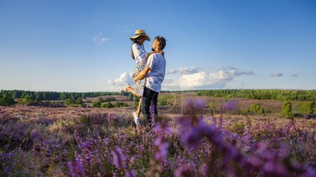 Foto de Posbank National Park Veluwe, brezo rosa púrpura en flor, calentador en flor en el Veluwe por las colinas del Posbank Rheden, Países Bajos. pareja de hombres y mujeres en los campos de Heather al atardecer - Imagen libre de derechos