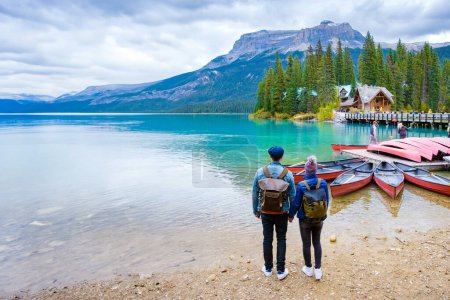 Téléchargez les photos : Parc national Emerald Lake Yoho Canada Colombie-Britannique. un beau lac dans les Rocheuses canadiennes pendant la saison automnale. Un couple d'hommes et de femmes debout au bord du lac regardant les montagnes - en image libre de droit