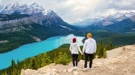 Téléchargez les photos : Lac Peyto Parc national Banff Canada. Mountain Lake comme Fox Head est populaire parmi les touristes au Canada conduisant la promenade des Glaciers. couple d'hommes et de femmes regardant sur le lac de couleur turqouse - en image libre de droit