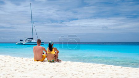 Téléchargez les photos : Un couple d'hommes et de femmes lors d'une excursion en bateau à la petite île de Curaçao à la turque couleur océan, Klein Curaçao île avec plage de sable blanc tropical à l'île des Caraïbes de Curaçao Caraïbes - en image libre de droit
