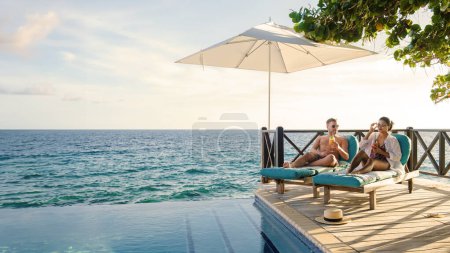 Curaçao un couple homme et femme d'âge moyen se détendre près de la piscine pendant les vacances, les hommes et les filles près de la piscine à Curaçao pendant les vacances sur une île tropicale vacances de luxe