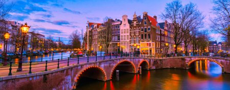 Téléchargez les photos : Canal d'Amsterdam le soir au coucher du soleil, pont du canal d'Amsterdam avec vieilles maisons historiques la nuit aux Pays-Bas - en image libre de droit