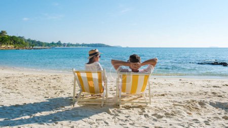 Photo for Koh Samet Island Rayong Thailand, the white tropical beach of Samed Island with a turqouse colored ocean, a couple of men and woman relaxing in a beach chair looking out over the ocean - Royalty Free Image
