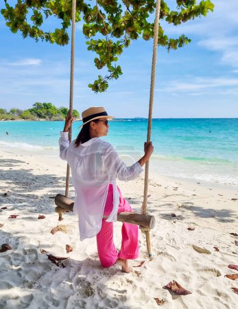 Téléchargez les photos : Femme asiatique sur une balançoire à la plage de Koh Samet Island Rayong Thaïlande, la plage tropicale blanche de Samed Island avec un océan de couleur turque - en image libre de droit